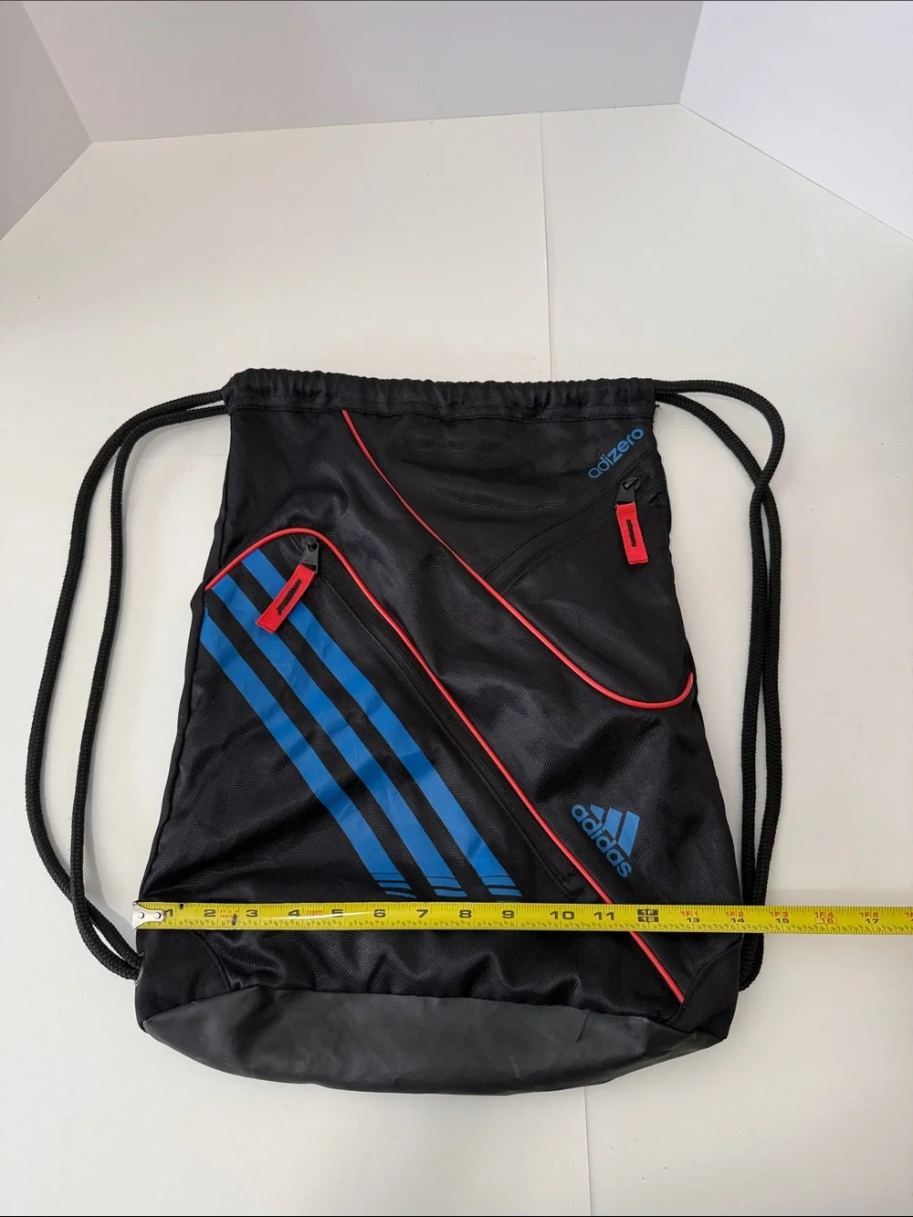 adidas Black Drawstring Backpack with Blue Stripes and Red Accents